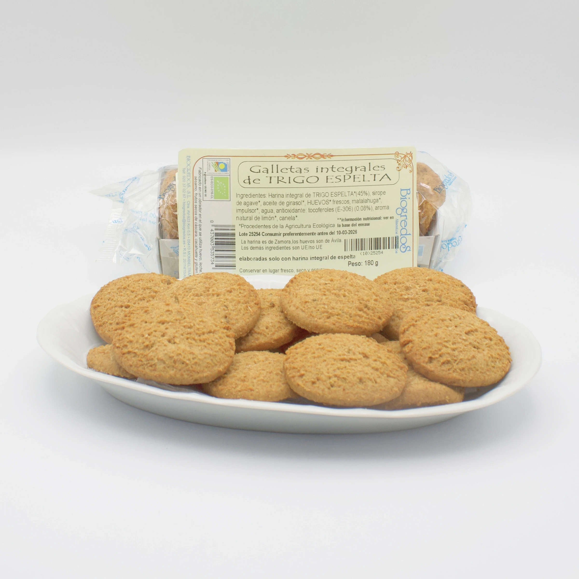 galletas integrales de trigo espelta ecológicas envasadas y unas pocas en un plato