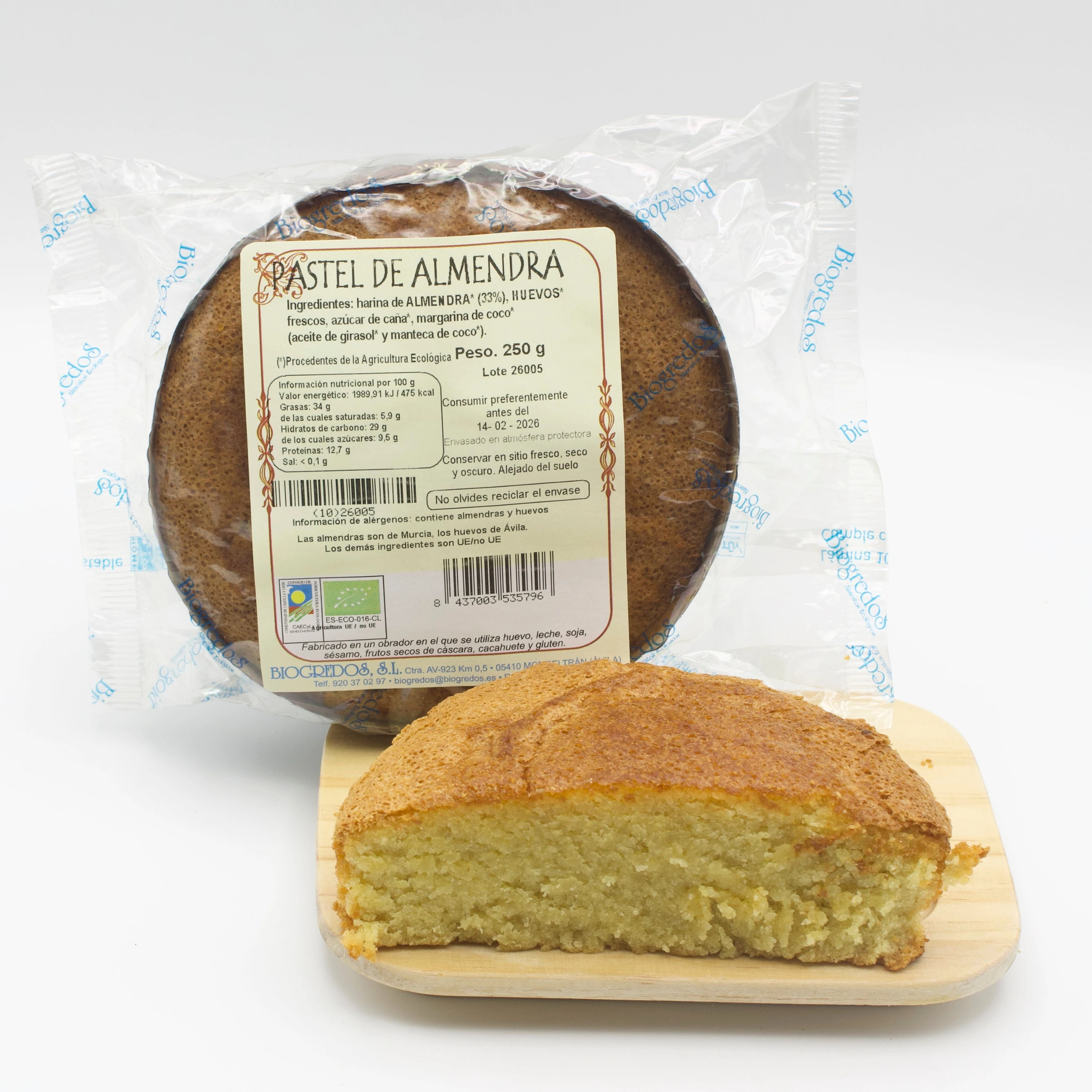 pastel de almendra ecológico envasado y otro pastel cortado por la mitad en plato de madera